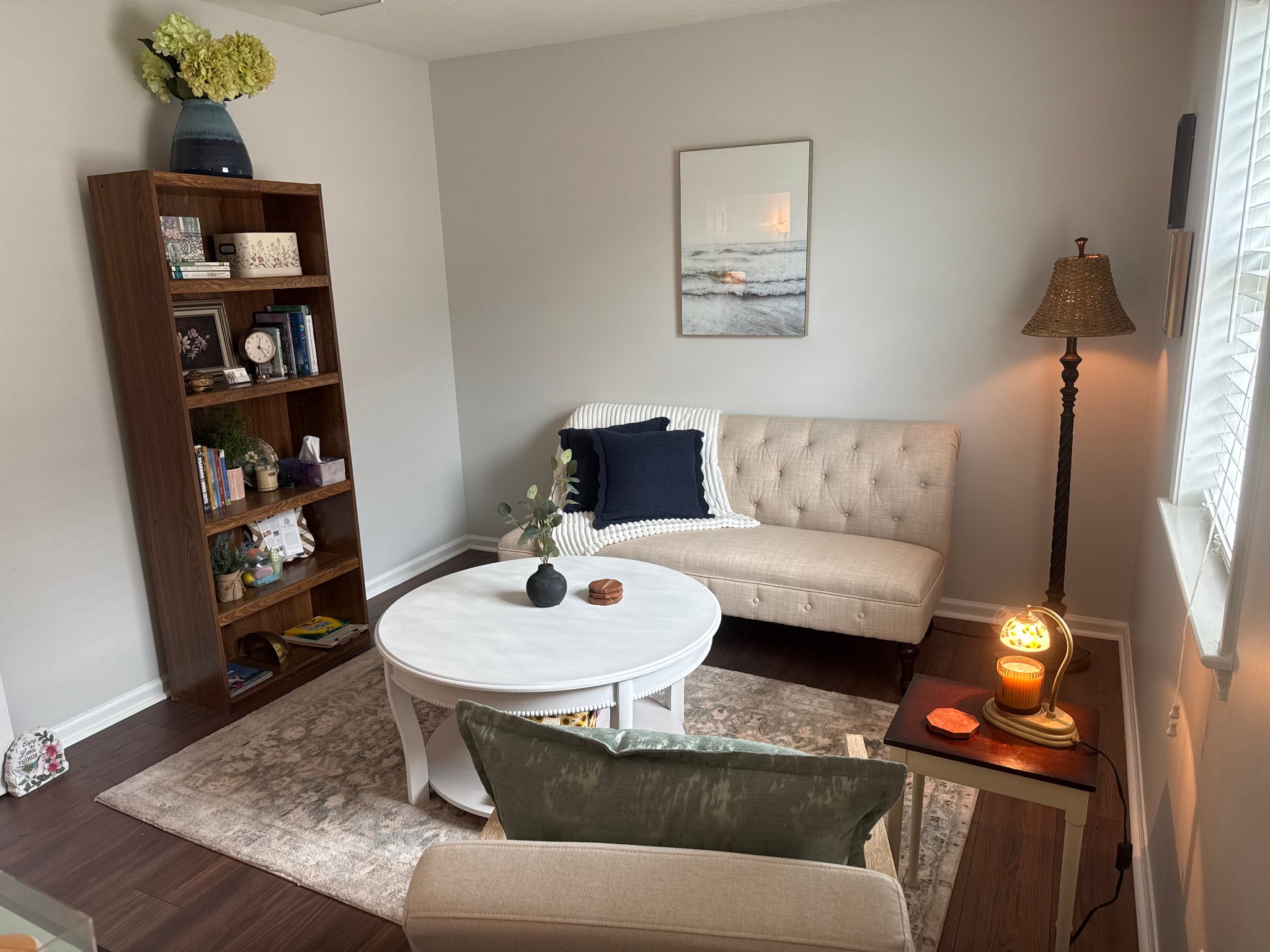 Karlyn Eddy's counseling office — bookshelf, tufted sofa, and round coffee table